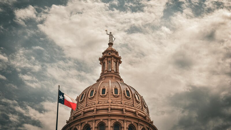 Texas State Capitol building in Austin, Texas with Texas flag